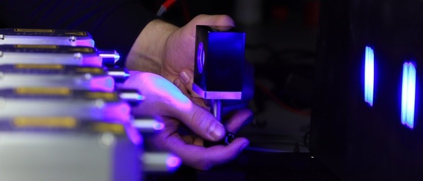 Ouvrier r&eacute;glant une machine de d&eacute;coupe laser